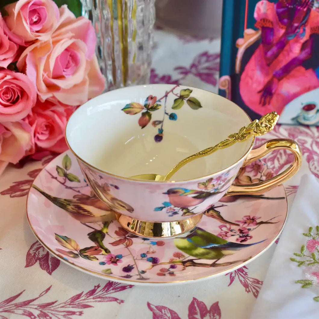 Teetasse und Untertasse in Rosa und Gold mit Vogelmotiv