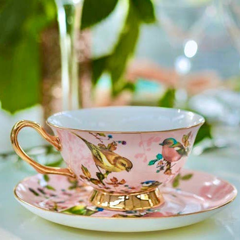 Teetasse und Untertasse in Rosa und Gold mit Vogelmotiv